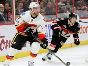 Calgary Flames' T.J. Brodie clears the puck from Ottawa Senators' Jean-Gabriel Pageau in the corner during first-period action between at Canadian Tire Centre in Ottawa, Ont., on Thursday, Jan. 26, 2017. Julie Oliver/Postmedia