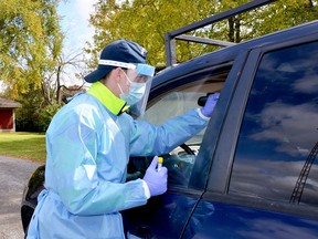 POP-UP SITES CONTINUE
Jeff Sherf reaches in with a swab to test the occupant of the car at the Merrickville pop-up COVID-19 testing centre held on Saturday behind the Merrickville Community Centre. More pop-up sites were planned for Athens Tuesday and Gananoque on Thursday. (Please see story on Page A3)