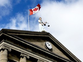 The Canadian Flag flies over the statue of Sally Grant at the Brockville courthouse on Thursday afternoon. (RONALD ZAJAC/The Recorder and Times)