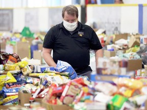 Jeff Comiskey sorts donations at Thames Campus Arena in Chatham during the May 16 Miracle food drive. A similar food drive for Lambton County is being planned for Nov. 7. Mark Malone/Postmedia Network