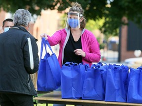 Kelly Ladd gives out meals Friday during the annual Entegrus Thanksgiving luncheon outside the Spirit & Life Centre. Mark Malone