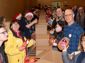 Several volunteers have some fun while packing food boxes for the Chatham Goodfellows No Child Without A Christmas campaign at the Spirit & Life Centre in Chatham in this file photograph from December 2018. File photo/Postmedia Network