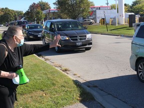 Shirley Roebuck, chair of the Ontario Health Coalition for Chatham-Kent, Sarnia, Wallaceburg and Walpole Island First Nation, waves to someone taking part in a protest to raise awareness about ongoing issues is long-term care homes in Ontario. The vehicle motorcade that circled Chatham-Kent Leamington MPP Rick Nicholls' Chatham constituency office on Thursday, was one of several protests held across the province, including at Queen's Park. Ellwood Shreve/Chatham Daily News/Postmedia Network