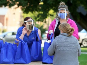 Kelly Ladd, right, and Sarah Regnier are seen in this file photo from Oct. 9, giving out meals during the annual Entegrus Thanksgiving luncheon outside the Spirit & Life Centre in Chatham. Entegrus has also donated $280,000 to help the United Way of Chatham-Kent and Salvation Army organizations in Chatham-Kent, St. Thomas and Strathroy provide assistance to those in need during the pandemic.