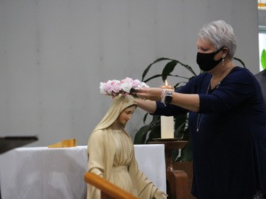 Lynn Pomainville, of the Alexandria-Cornwall Diocese, places a crown of roses on Mary during the Rosary Rally.Photo on Saturday, October 10, 2020, in Cornwall, Ont. Todd Hambleton/Cornwall Standard-Freeholder/Postmedia Network
