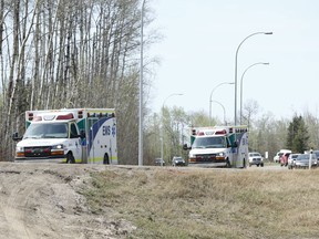 Ambulances head south near Gregoire Lake, near Anzac, Alta., on Wednesday May 4, 2016. Ian Kucerak/Postmedia Network