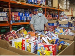 Glen Pearson, co-executive director of the London Food Bank, helps sort donations for the agency's Thanksgiving food drive Tuesday. Derek Ruttan/The London Free Press