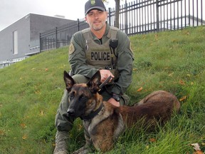 Const. Jeff Dickson with Kingston Police's new service dog, Bask, at their headquarters on Friday. (Steph Crosier/The Whig-Standard)