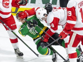 Jonathan Gruden of the London Knights gets mugged by Robert Calisti of the Soo Greyhounds during the first period of their game on Feb. 28, 2020 in London. (Derek Ruttan/The London Free Press)