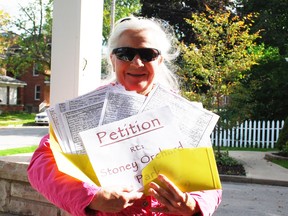 Maggie Bishop of Owen Sound holds up the petition she created that opposes a proposal by Barry's Construction to purchase a section of city-owned Timber McArthur/Stoney Orchard Park in the city's northeast quadrant. DENIS LANGLOIS