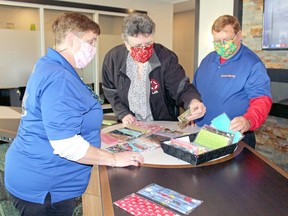 Lana Mitchell, executive director of LIPI, checks out some of the face masks created by Pauline Brown, left, while Ken Brown helps organize them, Monday, at Homewood Suites.
PJ Wilson/The Nugget