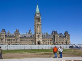 Visitors stop to listen to the bells on Parliament Hill May 5, 2020.