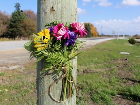 Flowers are attached to a pole near where a fatal crash occurred two days earlier at Petrolia Line and Kimball Road on Friday October 23, 2020 in St. Clair Township, Ont. (Terry Bridge/Sarnia Observer)