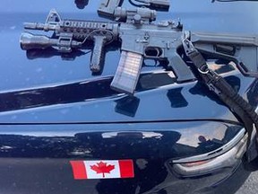 A police-issued carbine rifle is pictured alongside a paintball rifle. (Submitted)