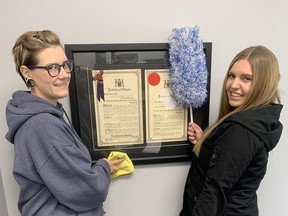 Danielle Strong and Samantha Hardy from My Fantastic Maid stop by the United Way office to discuss their three-month promotion where Fantastic Maid will donate 10 per cent of their profits to the United Way of Sarnia Lambton until Dec. 31. While at the office, the Fantastic Maid employees dust off the original Letters Patent of the United Way from Oct. 11, 1957 when the organization was known as the Sarnia and District Community Chest. United Way photo