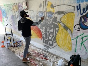 Justin Beamish painting the newest addition to the graffiti tunnel in Stony Plain.