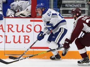 Sudbury Wolves defenceman Jack Thompson (22) plays the puck while under pressure from Peterborough Petes forward Chad Denault (22) during first-period OHL action at Sudbury Community Arena on Oct. 4, 2019. Ben Leeson/Sudbury Star