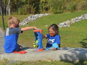 Kasey Stahl and Nwaabdasse Trudeau, Senior Kindergarten students at Princess Anne Public School, work together on a sensory activity in the outdoor garden. Supplied