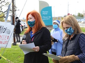 Lynn Logtenberg, left, addresses a crowd while her sister, Helene Lalonde, looks on at a protest Thursday outside Pioneer Manor.