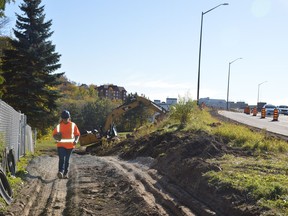 Interpaving worker Laura Swanson ascends a hill Tuesday at the corner of Notre Dame Avenue and Leslie Street, where a project to rehabilitate sidewalks and extend a cycling lane through the Flour Mill is now underway. Jim Moodie/Sudbury Star