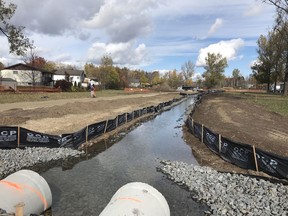A worker walks along a newly constructed path alongside a recently uncovered section of Junction Creek at Lions Park in Garson, Ontario on Wednesday, October 14, 2020. When culverts began to fail in a covered section of the creek, not far from its headwaters at Garson Mine, the City of Greater Sudbury opted to uncover the section running through the park -- a process called daylighting. The project has earned praise from both the Nickel District Conservation Authority, which owns the land and leases it to the city, and the Junction Creek Stewardship Committee, which has been giving input on the project. Ben Leeson/The Sudbury Star/Postmedia Network