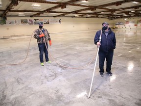 Volunteer Ray Joanisse, left, and facility manager Tom Leonard prepare to flood the surface at Curl Sudbury in Sudbury, Ont. on Tuesday October 20, 2020. Leonard said it will take about two weeks to create the ice surface for curling. The 2020-2021 season begins on Nov. 2 at Curl Sudbury.