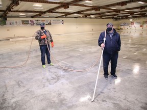 Volunteer Ray Joanisse, left, and facility manager Tom Leonard prepare to flood the surface at Curl Sudbury on Oct. 20, 2020.