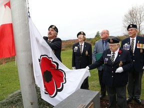 Chris Peters, left, of Branch 564, prepares to raise a poppy flag during a ceremony to launch the Poppy Campaign at Branch 76 of the Royal Canadian Legion in 2018.