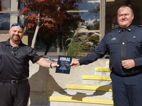 Sarnia-Lambton Crime Stoppers board president Sean Roberts receives the Donald G. Hawkins OACS President's Award from Sarnia Police Chief Norm Hansen. Handout/Sarnia This Week