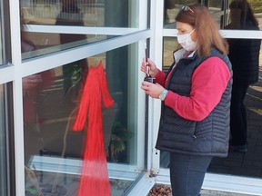 Timmins Police Community Liaison Coordinator Brenda Beaven  paints a "red dress," the emblem and recognized symbol of Missing and Murdered Indigenous Women and Girls at the entrance of the Timmins Police Service building. This gesture is meant to raise awareness and offer a show of support for the National Inquiry and its mandate to look into and report on the systemic causes of all forms of violence against Indigenous women and girls, including sexual violence. Oct. 4th was the National Day of Action for Missing and Murdered Indigenous Women and Girls.

Supplied
 


 




 

.