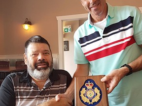 Retired OPP Const. John Hill, left, receiving his retirement plaque from Sgt. Darren Miller.

Supplied