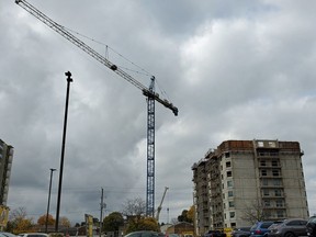 A construction crane looms over the Woodstock skyline on a gloomy overcast day more than 10 stories in the sky as part of the latest apartment building on the corner of Dundas Street and Clarke Street South in Woodstock, Ont. Greg Colgan/Woodstock Sentinel-Review/Postmedia Network