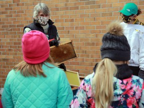 Kenora Beekeeping Club members Ingrid Braun, left and Shelley Bujold show St. Louis School students what the inside of a beehive looks like during a presentation on Thursday, Oct. 15.