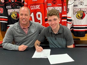 Attack general manager Dale DeGray poses with 2019 first-round pick Deni Goure as the Grande Pointe native puts pen-to-paper on a standard player agreement and education package in June 2019 at the team's awards and barbecue. Photo by Attack Hockey