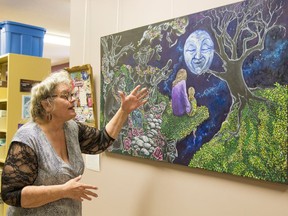 Artist Jacquie Paul from Rochfort Bridge describes a painting she created. It is on display at the Whitecourt Library as part of Family Violence Prevention Month.