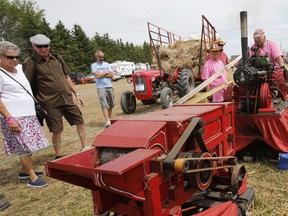 Wally Biernacki of Orono, Ont., operates a model thresher as 250 threshing machines attempt to break the world record by operating simultaneously on the same site in St. Albert on Sunday, August 11, 2019.