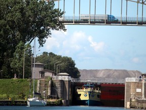 A northbound transport crosses the International Bridge while Soo Locks Boat Tours exits Canadian canal on the St. Mary's River in Sault Ste. Marie, Ont., on Thursday July 30, 2020. (BRIAN KELLY/THE SAULT STAR/POSTMEDIA NETWORK)