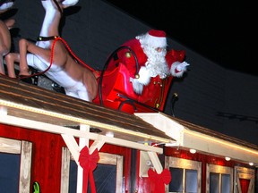 Santa Claus waves at children in a car Saturday night during the 75th annual Kiwanis Owen Sound Santa Claus Parade, which was held as a drive-through event this year in the Harry Lumley Bayshore Community Centre's parking lot due to the COVID-19 pandemic. DENIS LANGLOIS