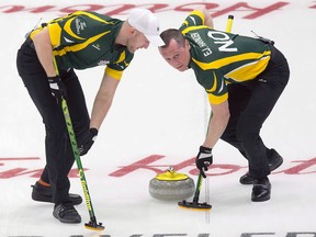 No strangers to Brier competition, brothers Ryan Harnden, left, and E.J. Harnden sweep a shot by skip Brad Jacobs