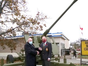 Les Burden, president of the Tillsonburg Military History Club, on the left, presents a Local Hero award to Don Burton, chair of the Tillsonburg Legion Branch 153 poppy campaign for his efforts in refurbishing the 1943 40mm anti-aircraft gun in front of the Tillsonburg Legion. (Chris Abbott/Norfolk and Tillsonburg News)