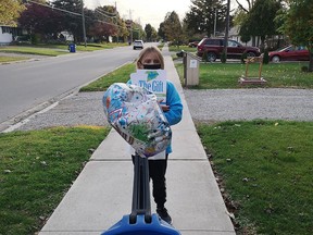 Mattea Marchand, 9, collected $1,715 for ROCK Missions by walking in Chatham and honking a horn to get people's attention. She also collected dry goods and carried them in the wagon. (Handout/Postmedia Network)