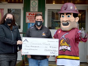 Roxanne Daoust, executive director of The Venture Centre, presents a $5,000 cheque on behalf of the organization to the Timmins Rock outside the McIntyre Arena on Friday. Accepting on behalf of the NOJHL squad are President Ted Gooch and mascot Mac. The Rock were one of 18 organizations to receive funds from The Venture Centre’s Community Recovery Fund. THOMAS PERRY/THE DAILY PRESS/POSTMEDIA NETWORK