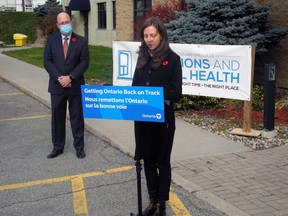 Patricia Kyle of the local addictions and mental health agency, reacts to MPP Steve Clark's (background) announcement of more money. Wayne Lowrie/Recorder and Times