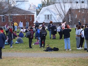 Students stand outside Sudbury Secondary on Monday morning after the school was evacuated due to a bomb threat.