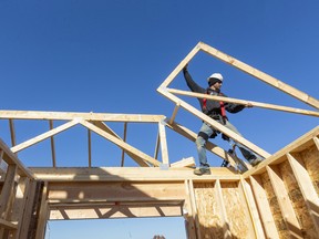 Jeff Apthorp, owner of Forest City Framing grabs a joist for a new home they are building in a new subdivision on the south side Strathroy-Caradoc. Mike Hensen/Postmedia Network
