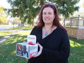 Erin Pollard, president of MADD Sarnia-Lambton, holds a Red Ribbon Project box that will be placed at local businesses through the holidays. Paul Morden/Postmedia Network