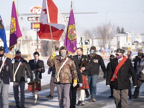 The colour guard leads the parade to the Cenotaph shortly before 11 am in Grande Prairie.  A couple of hundred people braved cool temperatures to commemorate Remembrance Day at the Jubilee Park Cenotaph. Most of those in attendance were wearing masks and people were spaced out to achieve social distancing.