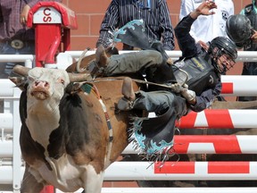 Ty Pozzobon from Merritt, BC gets air of the bull named Chicken Bone in bull riding action at the Calgary Stampede in Calgary, Alta.Saturday July 11, 2015.