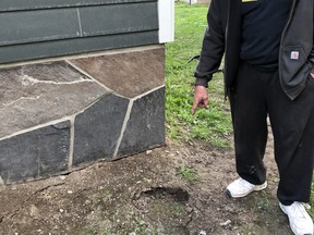 Exshaw resident Brian Thompson points to one of the sink holes forming outside his house on June 3. "I have lived here 33 years, and I have never seen flooding like this before. I am running four pumps right now," said Thompson last June. Photo credit Marie Conboy/ Postmedia.