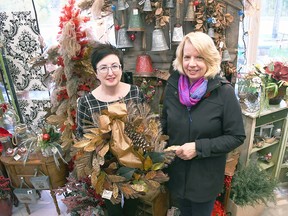 Melodee Delrue, owner of Syd Kemsley Florist, left, and Marianne Johnstone from IODE Captain Garnet Brackin hold up a wreath inside Delrue's Chatham store Oct. 30, 2019. The 2020 edition has been replaced with a series of draws at participating florist and plant businesses. (Tom Morrison/Postmedia)